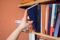 Woman choosing favourite book from home library