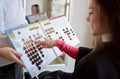 Woman choosing hair color from palette at salon