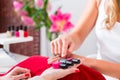 Woman choosing nail polish in beauty parlor