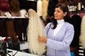 Woman choosing natural wig at specialty boutique