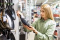 Woman choosing new frying pan to buy in home goods store