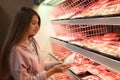 Woman choosing packed chicken meat Royalty Free Stock Photo