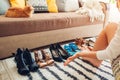 Woman choosing shoes at home. Hard choice to make from sandals, heels and flats