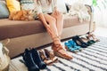 Woman choosing shoes and trying them on at home. Hard choice to make from sandals, heels and flats