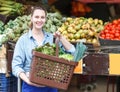 Woman is choosing vagetables with basket