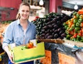 Woman is choosing vagetables with box in the market.