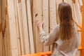 Woman choosing wooden plank in hardware store. Building materials for home renovation Royalty Free Stock Photo