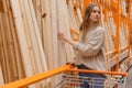 Woman choosing wooden plank in hardware store. Building materials for home renovation Royalty Free Stock Photo