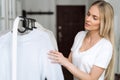 Woman choosing wool knitted sweater in pastel colours