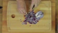 Woman Chopping Purple Onion at Wooden Kitchen Table