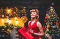 Woman in Christmas dress near the Christmas tree. Christmas preparation - luxury girl celebrating new year. Merry Royalty Free Stock Photo