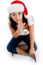 Woman with christmas hat and asking to keep silent