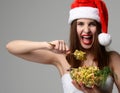 Woman in Christmas santa hat happy screaming eating Olivier salad