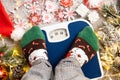 A woman in Christmas socks stands on the scales, weighs herself after gluttony during the holidays