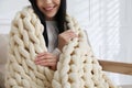 Woman with chunky knit blanket on sofa at home, closeup Royalty Free Stock Photo