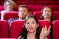 Woman in cinema with facial reaction