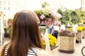 Woman on city tour taking picture of beautiful cafe flowers with her smartphone Royalty Free Stock Photo