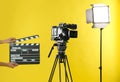 Woman with clapperboard near video camera in studio