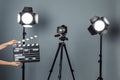 Woman with clapperboard near video camera in studio