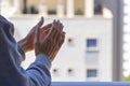 Woman clapping hands, applauding from balcony to support doctors, nurses, hospital workers. Applause to medical staff