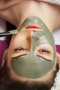 Woman with clay facial mask   in beauty spa. Skincare. Beauty Concept. Close-up portrait of beautiful girl applying facial mask. Royalty Free Stock Photo