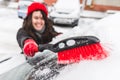 Woman clean car with brush after snow