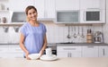 Woman with clean dishes near table in kitchen Royalty Free Stock Photo