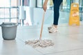 Woman cleaner mop floor at office, with water in plastic bucket and put sign as warning or caution for staff. Employee