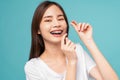 woman cleaning braces on teeth with dental floss on blue background, Concept oral hygiene and health care. Royalty Free Stock Photo