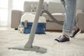 Woman cleaning carpet with a vacuum cleaner in room Royalty Free Stock Photo