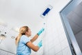 Woman Cleaning The Ceiling Of The Bathroom With Mop