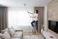 Woman cleaning ceiling with a mop. Housewife cleaning living room Royalty Free Stock Photo