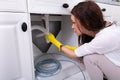 Woman Cleaning Clogged Sink Pipe