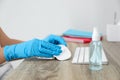 Woman cleaning computer mouse with antiseptic wipe in office, closeup Royalty Free Stock Photo