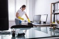 Woman Cleaning Computer In Office Royalty Free Stock Photo