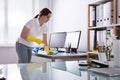 Woman Cleaning Computer In Office Royalty Free Stock Photo