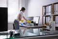 Woman Cleaning Computer In Office Royalty Free Stock Photo