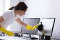 Woman Cleaning Computer In Office Royalty Free Stock Photo