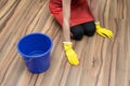 Woman cleaning concept. Woman washes the stain off the floor wearing yellow rubber gloves