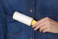 Woman cleaning denim shirt with lint roller, closeup Royalty Free Stock Photo