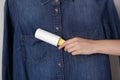 Woman cleaning denim shirt with lint roller, closeup Royalty Free Stock Photo