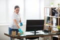 Woman Cleaning The Desk In Office Royalty Free Stock Photo