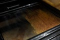 Woman cleaning dirty and greasy oven with stove in kitchen Royalty Free Stock Photo