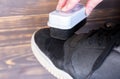 Woman is cleaning dirty men`s shoes with sponge Royalty Free Stock Photo