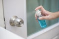 Woman is cleaning door handle with alcohol spray Royalty Free Stock Photo