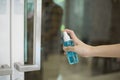 Woman is cleaning door handle with alcohol spray Royalty Free Stock Photo