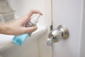 Woman is cleaning door handle with alcohol spray Royalty Free Stock Photo