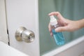 Woman is cleaning door handle with alcohol spray Royalty Free Stock Photo