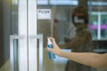 Woman is cleaning door handle with alcohol spray Royalty Free Stock Photo