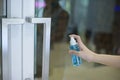 Woman is cleaning door handle with alcohol spray Royalty Free Stock Photo